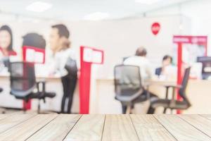 White wooden table top over blurred business customer service room with some of people photo