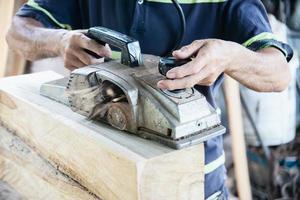 Man preparing electric router laminate trimmer machine tool - carpenter workshop concept photo