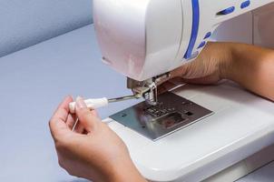 A woman is setting up her sewing machine photo