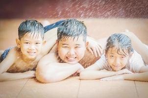 Children are happily playing with sprayed water during hot season photo