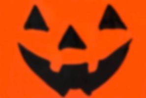 Blurred Halloween Jack O Lantern face over white background photo