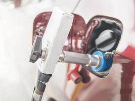 NGV, Natural Gas Vehicle, head dispenser with a car at the gasoline station in Thailand photo