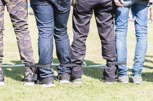 Five legged race outdoor party game, harmonious unity concept photo