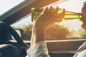 mujer bebiendo cerveza mientras conduce un coche foto