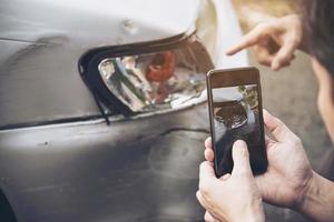 agente de seguros que trabaja durante el proceso de reclamación de accidentes de coche en el lugar - concepto de reclamación de seguros de personas y coches foto