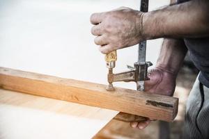 Man preparing electric router laminate trimmer machine tool - carpenter workshop concept photo