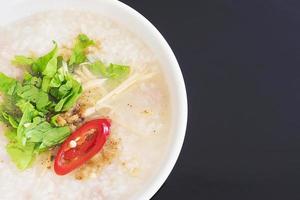 Desayuno de arroz hervido al estilo tailandés sobre fondo negro foto