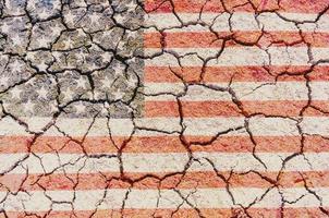 superposición de la bandera de EE.UU. en textura de suelo agrietado seco para uso de fondo foto