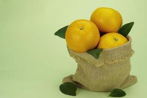 fruta naranja fresca y jugosa sobre fondo verde claro - fruta naranja tropical para uso de fondo foto