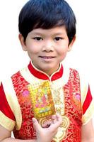 Boy is happily showing his money gift envelope in Chinese new year festival. Photo is focused at his eyes.