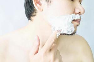 Man is smearing foam to his face prepare for shaving photo