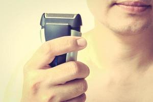 Vintage style photo of man is showing shaver after shaving