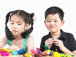 enfoque selectivo de niños asiáticos felices jugando juguetes de arcilla coloridos foto