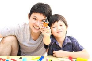 Father is playing Halloween clay with his son over white background.Photo is focus at hand photo