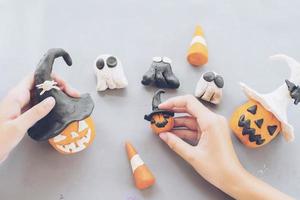 Girl is playing Halloween clay toy of jack o lantern pumpkin faces photo