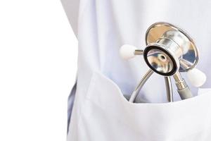 Stethoscope in pocket of doctor white uniform isolated over white background photo