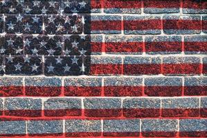 superposición de la bandera de estados unidos en la textura de la pared de ladrillo de granito antiguo para uso de fondo foto