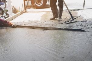 Workman doing road surface concrete pouring job in construction site photo