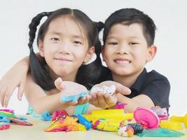 enfoque selectivo de niños asiáticos jugando juguetes de arcilla coloridos foto