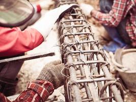 foto de estilo vintage de los trabajadores de la construcción están instalando varillas de acero en una viga de hormigón armado