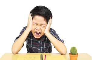 Angry boy is shouting while doing his assignment photo