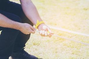 Man pulling rope in tug of war game in school sport day photo