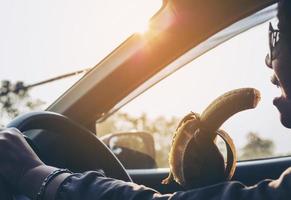 Lady eating banana while driving car dangerously photo