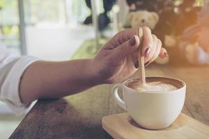 Closeup of lady preparing and eating hot coffee cup photo