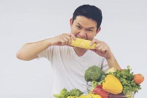 Vintage photo of Asian man showing enjoy expression of fresh colorful vegetables isolated over white background