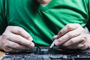 Man fixing laptop computer - technology computer reparing concept photo