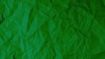 el fondo de papel verde está arrugado, creando una textura áspera con luces y sombras.