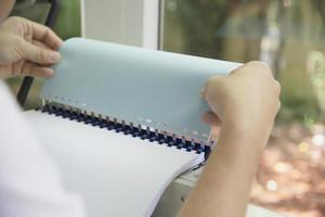 Man making report using comb binding machine - people working with stationary tools concept photo