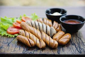 Fried sausages recipe with fresh tomato and sauces ketchup ready to be served, international food style concept photo