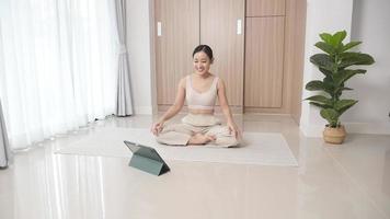 mujer haciendo yoga en casa manteniéndose saludable video