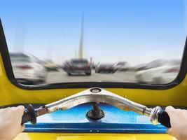 Front view of Thai Tuk Tuk looking out from inside with driver hands and road city view background photo