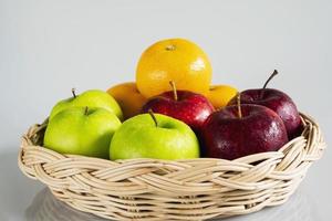 Fresh red green apple and orange over gray black background - fresh fruit background concept photo