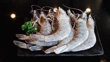 Fresh shrimp serve in black plate with - food with Covid-19 contagion inflection in Thailand photo