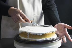 Lady making cake putting cream using spatula - homemade bakery cooking concept photo