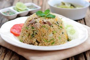 Fried rice with chili sauce and soup on wooden table photo