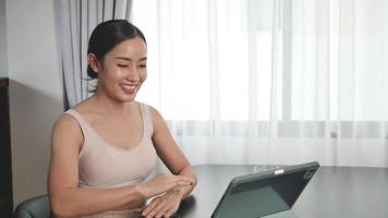 Asian women use tablet for online meetings to chat with girlfriends at home. video