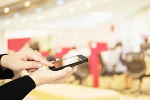 A man is using telephone over colorful blurred bokeh light in office and people background photo