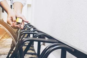 Man is locking key chain for his bicycle in campus photo