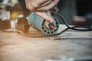 hombre que prepara la máquina herramienta cortadora de laminado del enrutador eléctrico - concepto de taller de carpintería foto