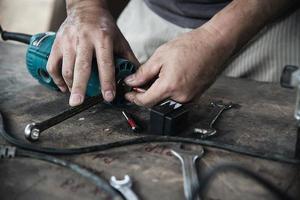 hombre que prepara la máquina herramienta cortadora de laminado del enrutador eléctrico - concepto de taller de carpintería foto