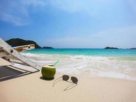 Relax beach chair with fresh coconut on clean sand beach with blue sea and clear sky - sea nature background relax concept photo