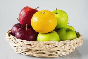 Fresh red green apple and orange over gray black background - fresh fruit background concept photo