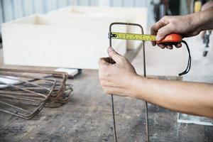 Carpenter working with wood furniture product preparation using hand tools and machine table station photo