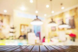 Brown wooden table over blurred photo of beautiful coffee shop for background use