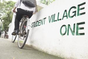 Student is riding bicycle in village green campus photo