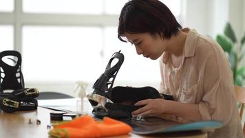 A woman grooming a snowboard board video